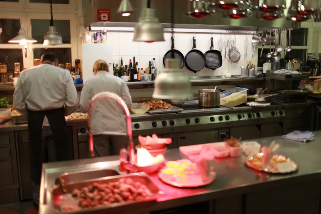 Zwei Köche arbeiten in einer Restaurantküche unter Wärmelampen